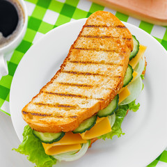 Sandwich with cheese, lettuce and vegetables for breakfast with coffee, top view