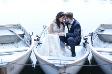 Beautiful bridal couple embracing in boat near harbour