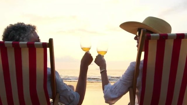 SLOW MOTION Retirement Vacation Concept, Happy Mature Retired Couple Enjoying Beautiful Sunset at the Beach
