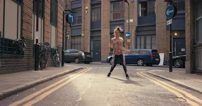 Contemporary funky mixed race woman street dancer dancing freestyle in the city