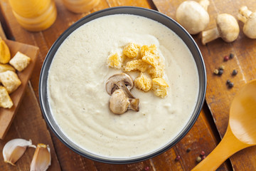 Delicious mushroom cream soup is cooking for lunch, ingredients on a table, European French food, top view