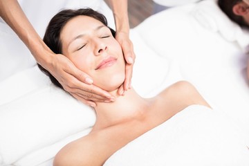 Fototapeta na wymiar Woman receiving a face massage from masseur