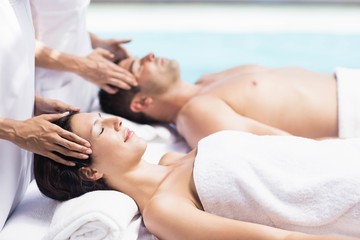 Obraz na płótnie Canvas Couple receiving a head massage from masseur