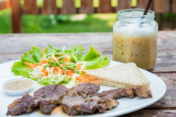 Grilled steak with fresh vegetables and ice coffee