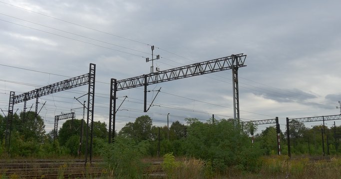 Supports Of The RAilroad Contact Network Electric Wires Railroad Tracks Green Trees Bushes Grass Grey Sky Cloudy Autumn Day Opole Poland