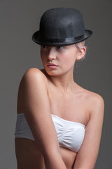 young lady posing in a black bowler hat
