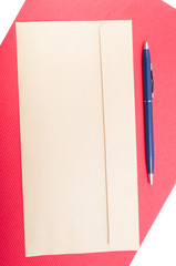 Blank envelop and pen on red backdrop