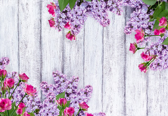 Fototapeta na wymiar Lilac flowers with roses on shabby wooden planks