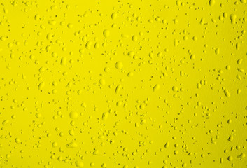 Texture water drops on the yellow bottle close-up as a background.