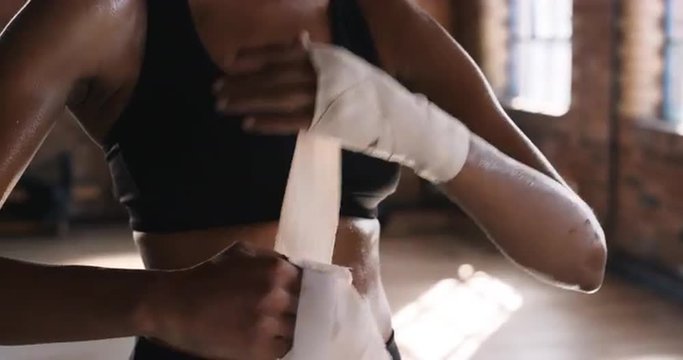 Kickboxing woman putting on punching wraps in fitness studio