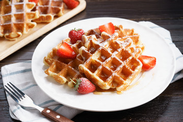Homemade waffles with syrup and strawberry.