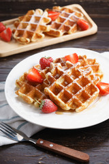 Homemade waffles with syrup and strawberry.