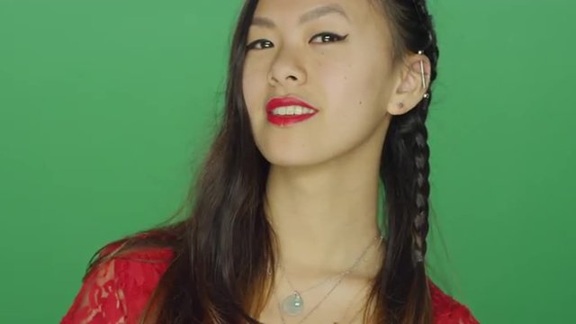 Young Asian woman staring and looking sexy, on a green screen studio background