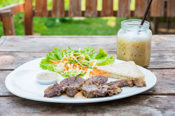 Grilled steak with fresh vegetables and ice coffee