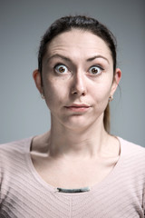 Portrait of young woman with shocked facial expression