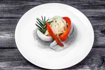 Marinated herrings on white plate