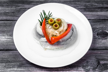 Marinated herrings on white plate