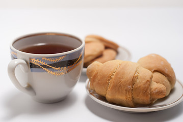 Cup of tea with pattern and fresh croissants