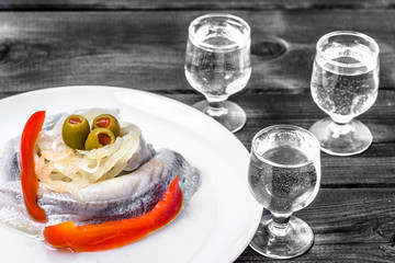 Traditional appetizer herring, cucumber and vodka