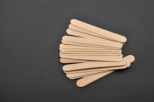 Picture of many wooden spatulas for wax depilation on black back