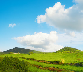 green hills under a blue sky with clouds