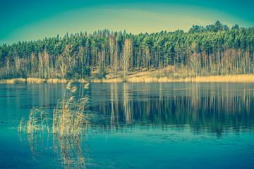 Vintage landscape of lake with calm surface.