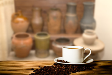 Coffee in a cup on wooden table opposite a defocused the interio