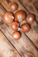 Fresh onion on old wooden burned table or board for background
