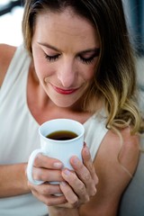 smiling woman sipping a cup of coffee