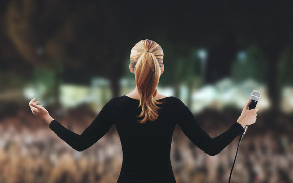 Donna su palco folla microfono canta