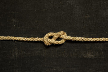 Eight knot on a black background. Photo of a series of nautical knots.