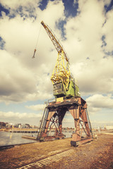 Retro stylized picture of an old rusty port crane in Szczecin, Poland.