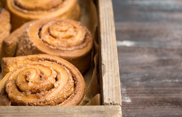 Cinnamon rolls on the wooden background