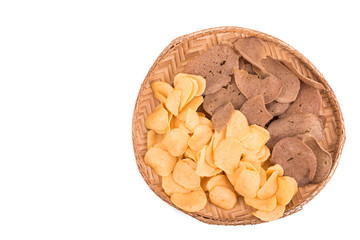 Dried raw prawn and fish crackers on traditional rattan tray in white background