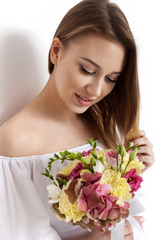 Happy surprised model woman smelling flowers