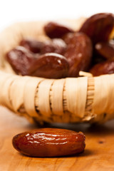 Sweet dried dates fruit in small bowl, mediterranean desert on w