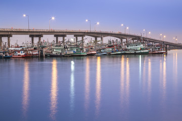 Fototapeta na wymiar Fishing boats under long bridge 