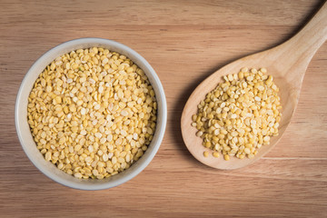 bowl of yellow bean seed and a scoop of yellow bean seed on a wo