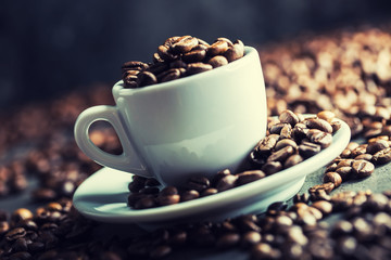 Coffee beans. Coffee cup full of coffee beans. Toned image.