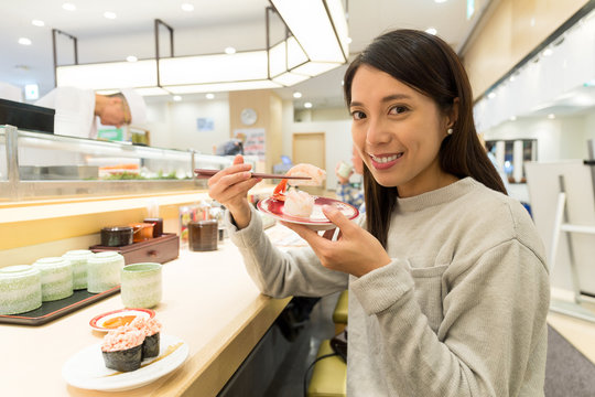 Woman having sushi at japanese restaurant
