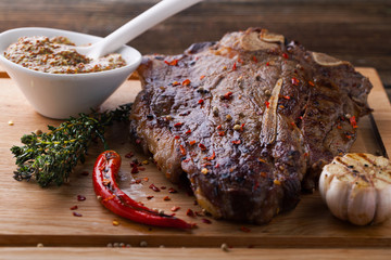Grilled marbled steak T-Bone with spices, thyme and garlic