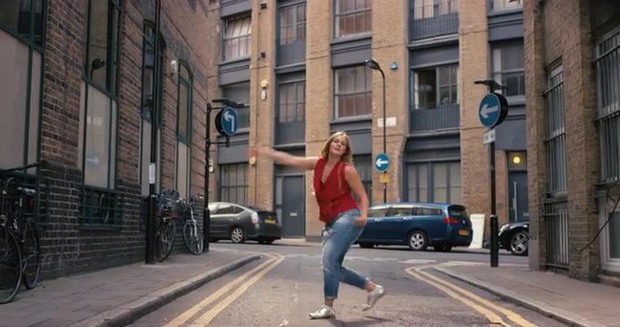 Contemporary funky caucasian woman street dancer dancing freestyle in the city