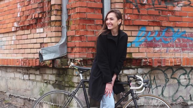 Beautiful Girl With a Bicycle, Waving Hello. the Girl is Very Attractive.