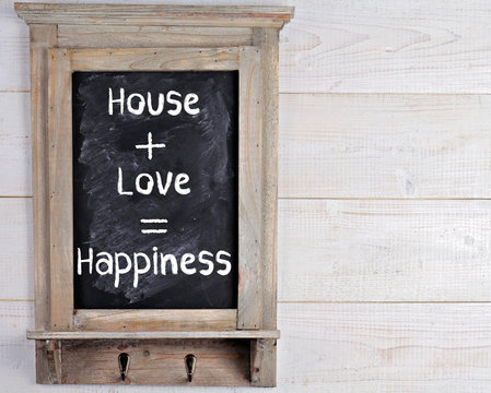 House, love, happiness motivation quote on blackboard. Scandinavian style home interior decoration.