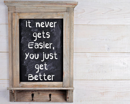 It never gets easier, you just get better motivation quote on blackboard. Scandinavian style home interior decoration.