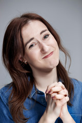 Woman is looking imploring over gray background