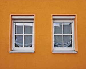 two windows and colorful orange wall