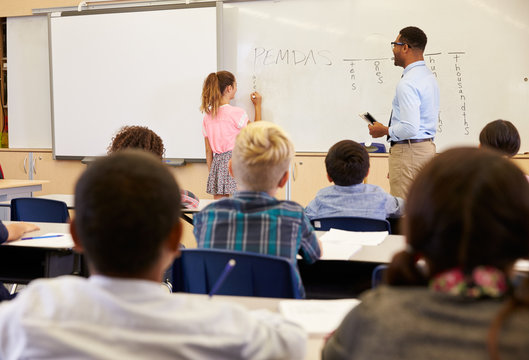 Pupil writing on the board in an elementary school lesson