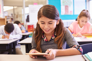 School girl using tablet computer in elementary school class