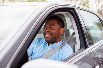 Happy African American male driver in car
